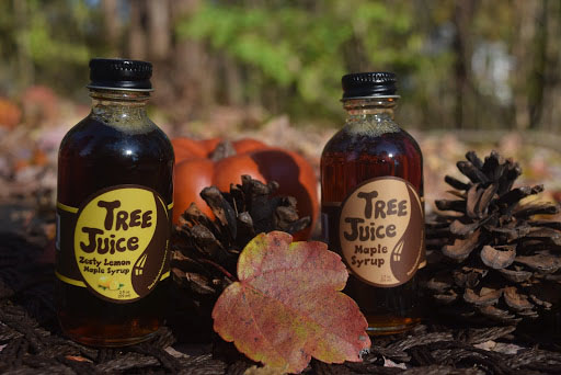 small bottles of maple syrup outdoors with leaves