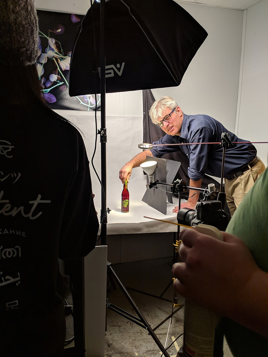 professor adjusting maple syrup bottle in photo studio