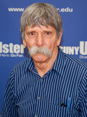 Portrait of John Frampton in front of SUNY Ulster backdrop