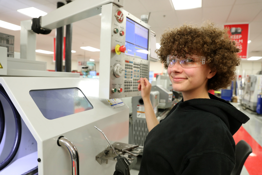 person in safety glasses working with cnc equipment