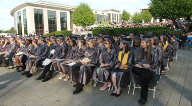 Graduates in robes and caps at outdoor ceremony